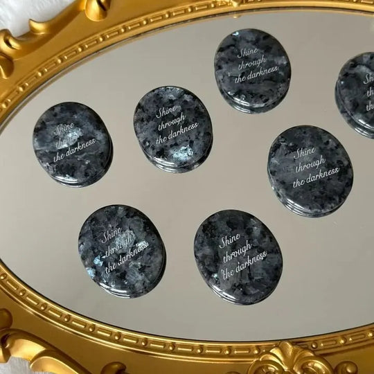 Engraved healing crystals with 'Shine through the darkness' on ornate gold mirror, ideal for spiritual growth and protection