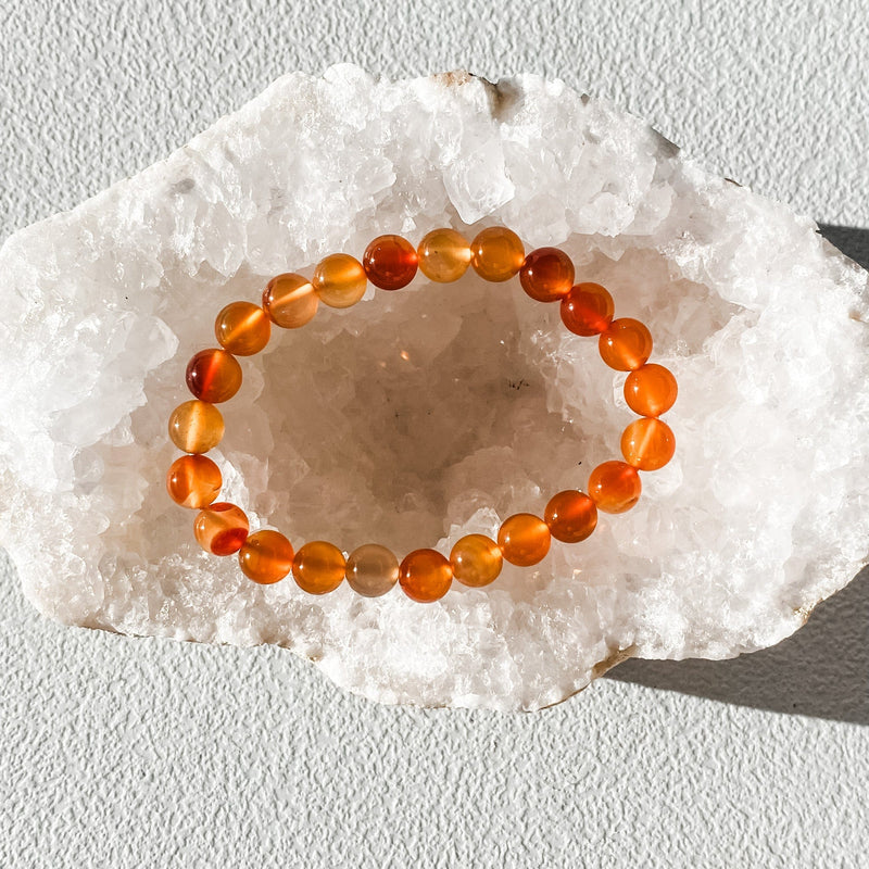 Orange carnelian crystal bracelet on white geode, healing stone jewelry for energy and protection