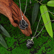 Handmade black crystal pendant necklaces with silver wire wrap, set on moss and wood for natural healing energy.