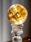 Golden citrine crystal sphere on glass stand for spiritual healing and positive energy