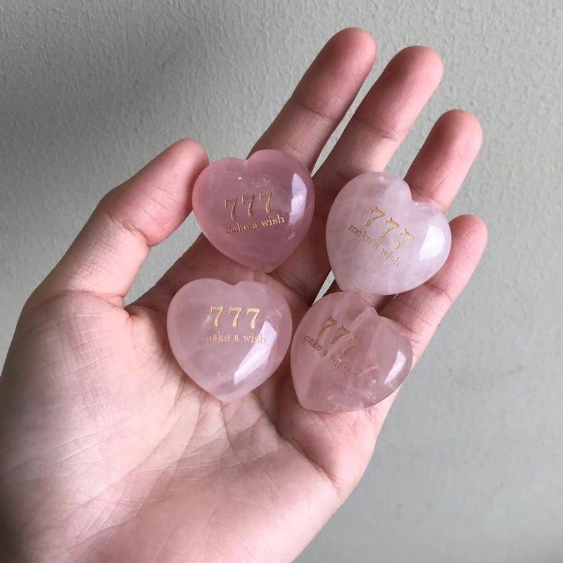 Four heart-shaped rose quartz crystals engraved with '777 make a wish' for love and spiritual growth