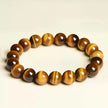 Tiger's Eye gemstone bracelet for protection and spiritual growth, featuring polished beads with golden-brown stripes.