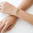 Person wearing a bracelet with green beads on a white background