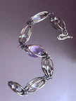 Handmade amethyst and clear crystal bracelet with wire-wrapped links for spiritual healing and chakra balance