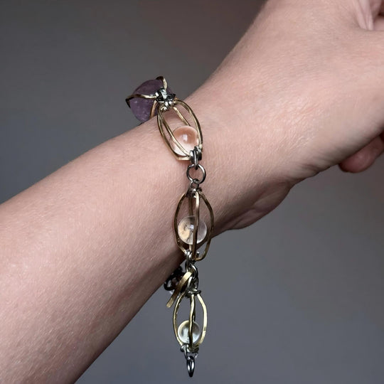 Handmade gemstone bracelet with amethyst and clear quartz, featuring gold and silver links for spiritual healing and chakra balance.