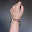 Hand wearing handmade gemstone bracelet with pink and clear crystals for love and healing