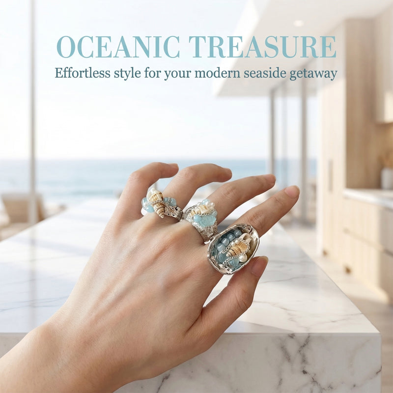 Hand wearing oceanic treasure rings with seashells and blue gemstones, perfect for seaside style