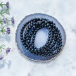 Black onyx beaded necklace on agate slice with lavender, for protection and spiritual healing