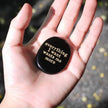 Hand holding black engraved stone with 'everything I want wants me more' for spiritual growth and manifestation