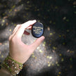 Hand holding black affirmation stone with gold text 'everything I want wants me more' for spiritual growth