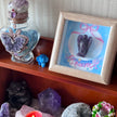 Amethyst angel crystal in dream-themed frame with butterfly jar, healing stones, and spiritual decor