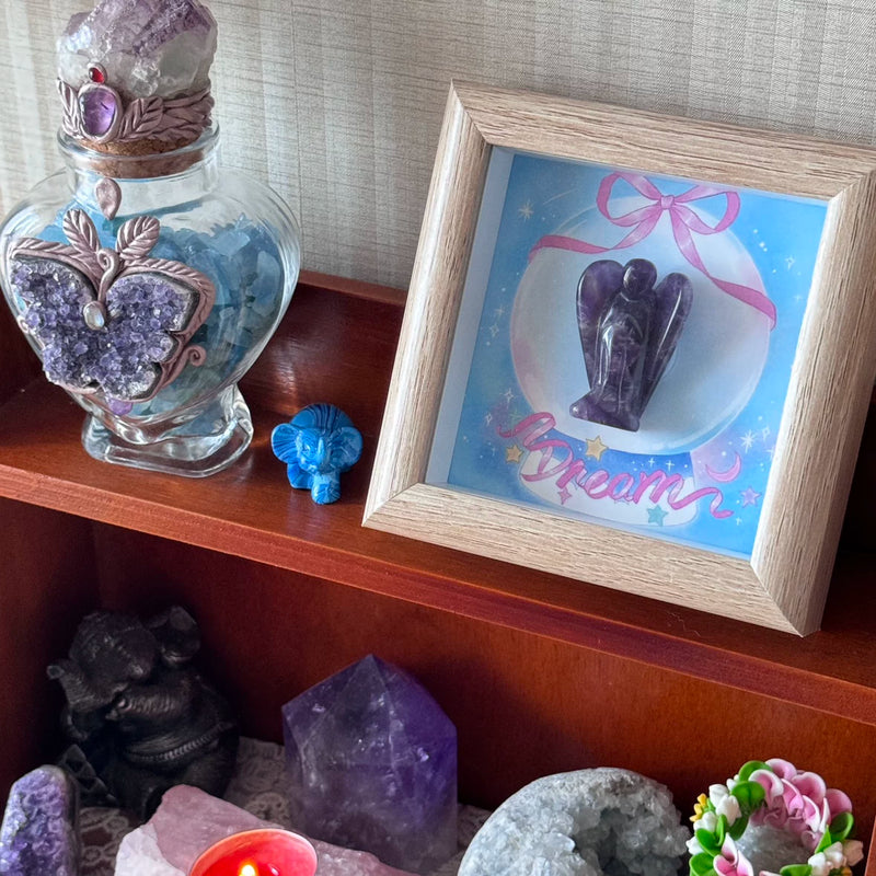 Amethyst angel crystal in dream-themed frame with butterfly jar, healing stones, and spiritual decor