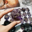 Hand holding amethyst crystal with 'I want it I got it' engraving, healing stone for manifestation and confidence