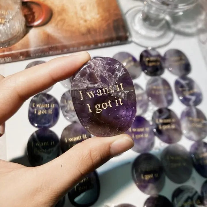Hand holding amethyst crystal with 'I want it I got it' engraving, healing stone for manifestation and confidence
