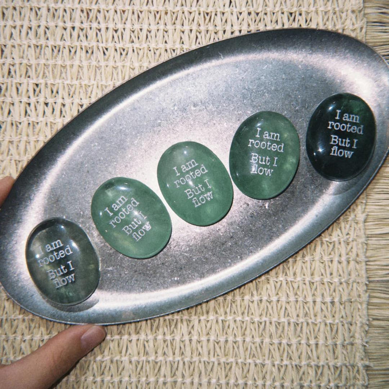 Green engraved healing crystals with 'I am rooted But I flow' on metal tray, spiritual growth stones