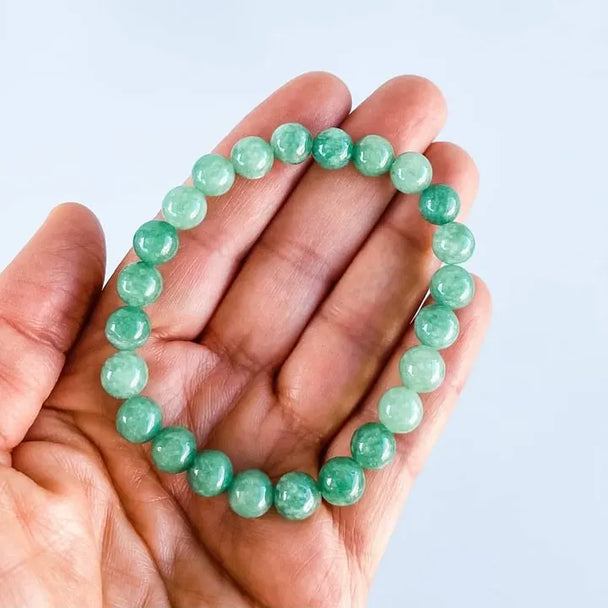 Hand holding green aventurine bracelet for healing and chakra balance, natural gemstone jewelry