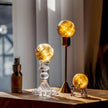 Glowing citrine crystal spheres on decorative stands for spiritual ambiance and chakra healing