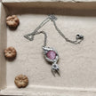 Handmade gemstone necklace with pink crystal pendant in silver setting, displayed in box with mini pumpkins