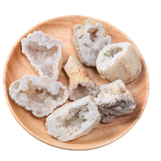 Raw geode crystal pieces for healing and spiritual growth, displayed on a wooden plate