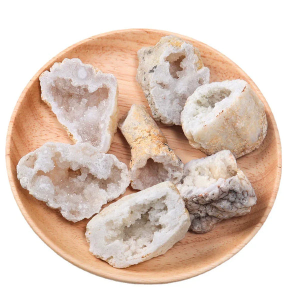 Raw geode crystal pieces for healing and spiritual growth, displayed on a wooden plate