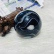 Polished black agate sphere with white banding, healing crystal for protection and spiritual growth
