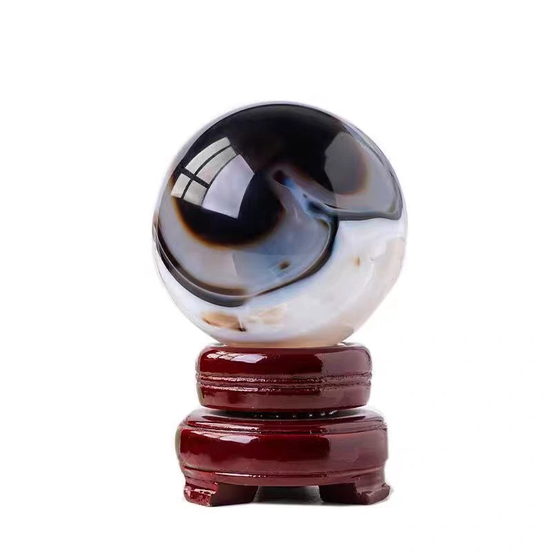 Polished agate crystal sphere on wooden stand for spiritual healing and protection