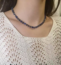 Lapis lazuli chakra necklace for spiritual healing and protection, worn with white crochet top