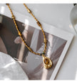 Gold beaded necklace with amber crystal pendant, handmade gemstone jewelry for spiritual healing and protection.