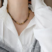 Tiger eye gemstone necklace for protection and spiritual growth, worn with white blouse