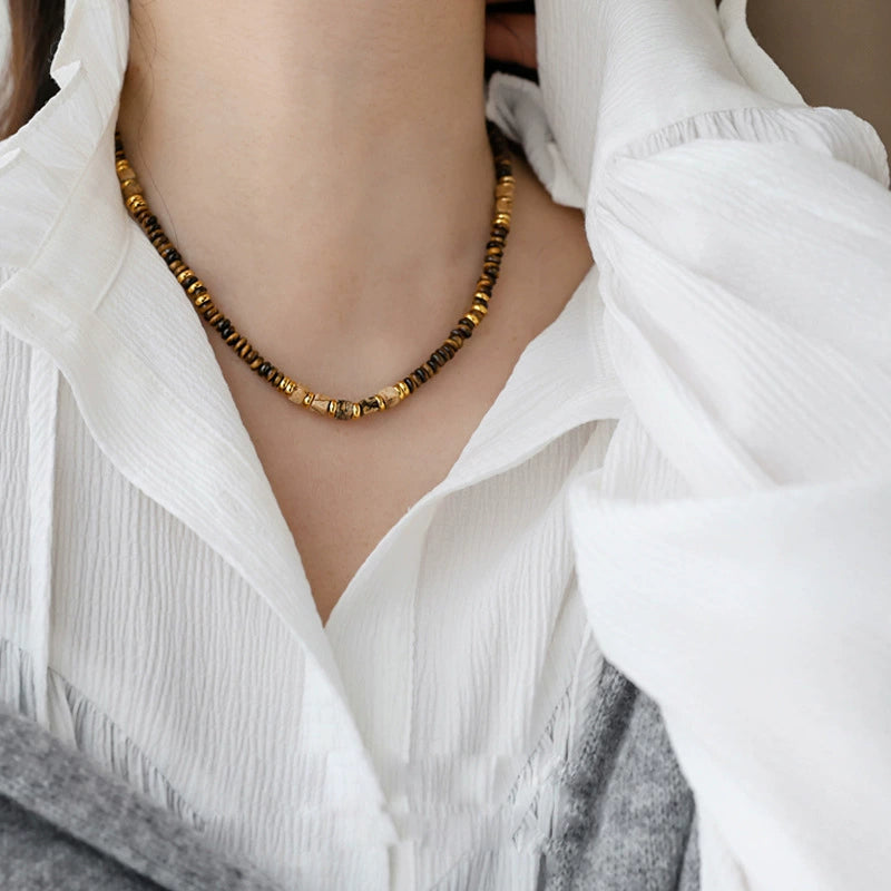 Tiger eye gemstone necklace for protection and spiritual growth, worn with white blouse