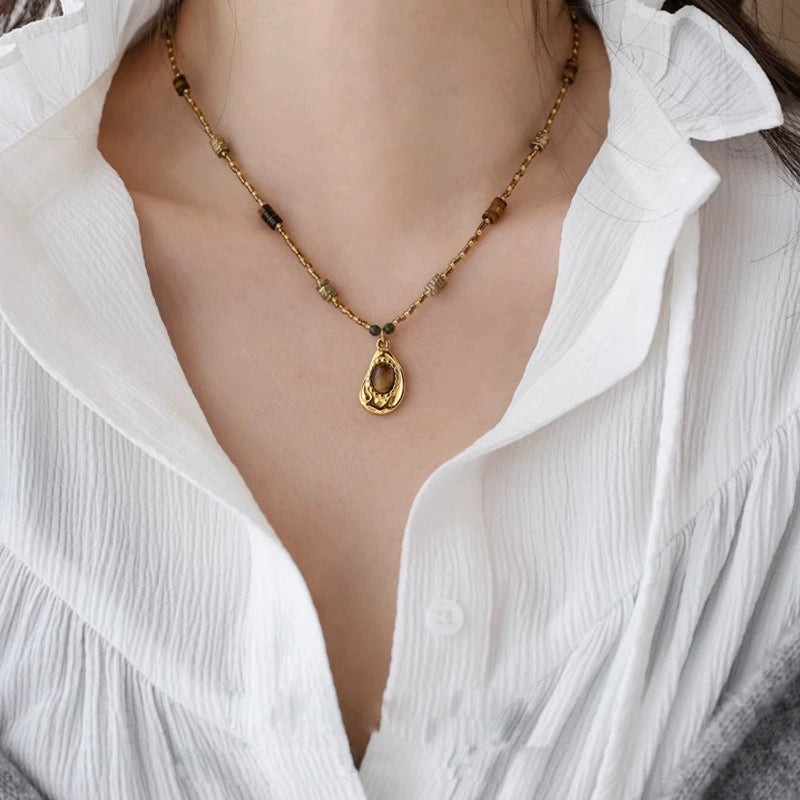 Gold-toned tiger eye pendant necklace with healing crystal beads for spiritual growth and protection