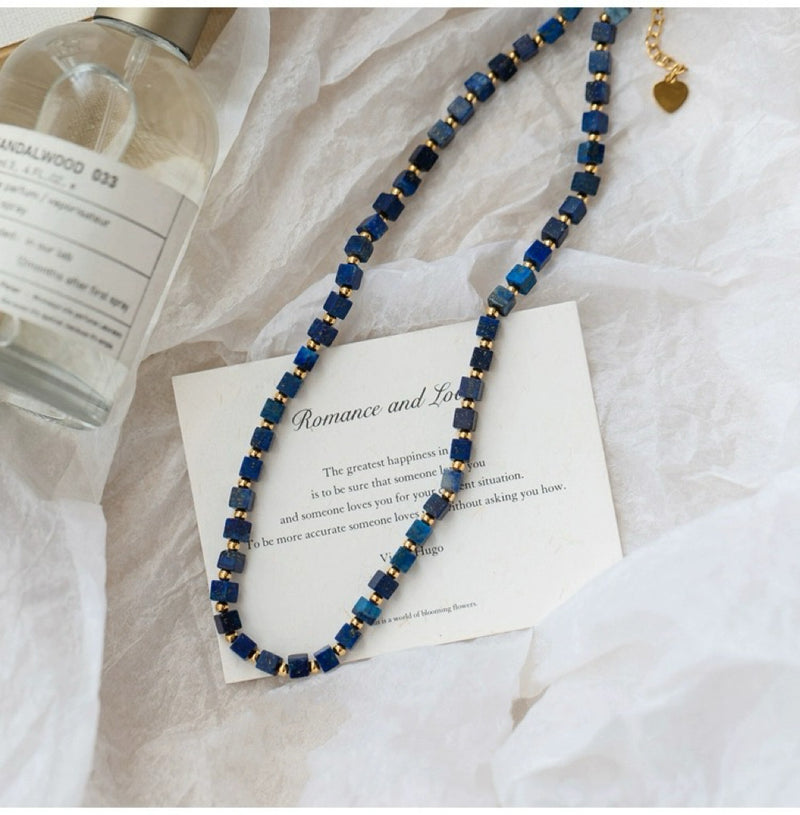 Lapis lazuli cube necklace with gold beads, romance quote card, and sandalwood spray for love and spiritual healing