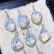Handmade moonstone pendants with wire-wrapped settings, featuring iridescent blue and white hues for spiritual healing and chakra balance.