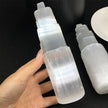 Hand holding a natural selenite spray bottle for crystal healing and spiritual cleansing