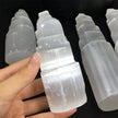 Hand holding natural selenite tower crystal for spiritual healing and protection, ideal for chakra alignment and anxiety relief