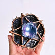 Hand holding a pentacle crystal holder with iridescent flower, ideal for healing crystals and spiritual decor.