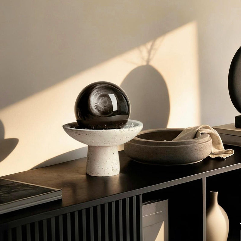 Black crystal sphere on white pedestal for home decor and spiritual energy