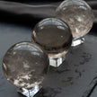 Three clear quartz crystal spheres on stands, ideal for healing, meditation, and spiritual growth.