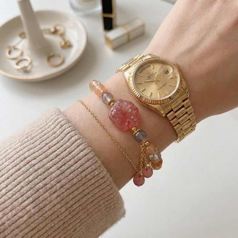 Hand wearing gold watch with pink crystal bracelet, gemstone jewelry for spiritual healing and protection