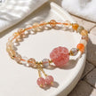Handmade gemstone bracelet with pink carved charm, gold accents, and crystal beads for spiritual healing and love energy.