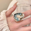 Handmade resin ring with seashell and blue beads, beach-inspired jewelry for spiritual calm