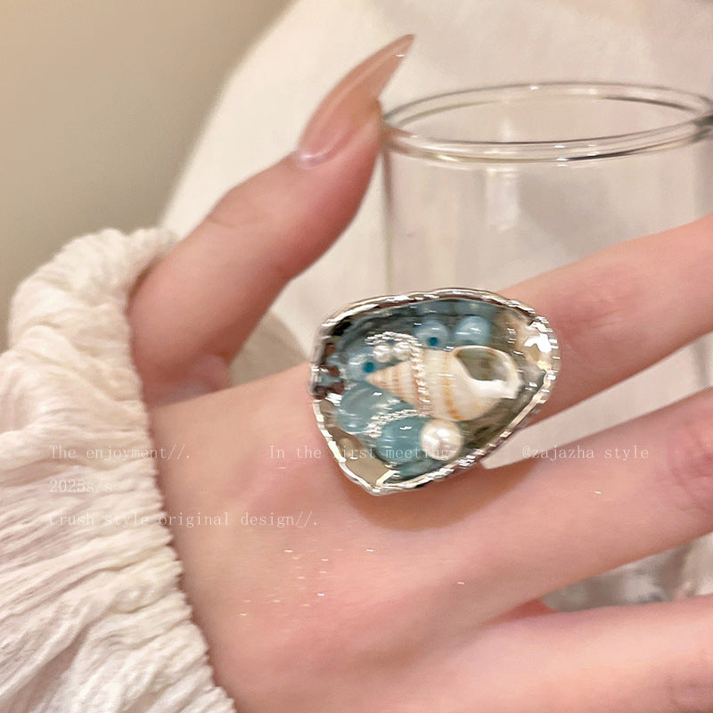 Handmade resin ring with seashell and blue beads, beach-inspired jewelry for spiritual calm