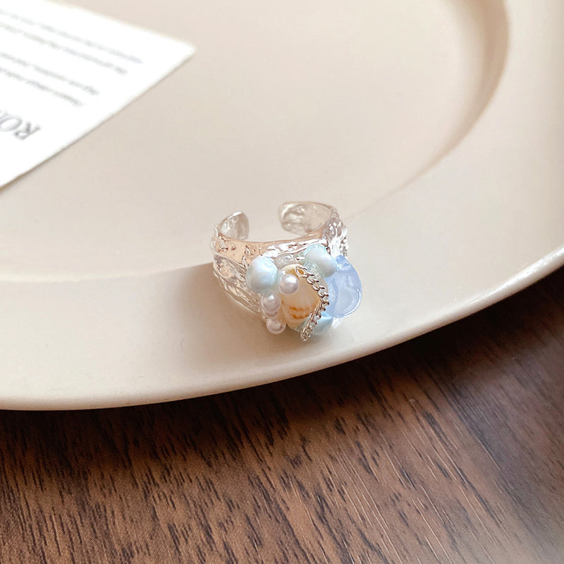 Handmade gemstone ring with blue chalcedony, pearls, and shell on textured silver band for spiritual healing