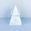 Clear quartz crystal bracelet on white marble pyramid, ideal for spiritual healing and energy balance