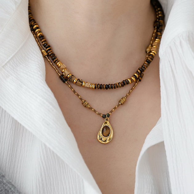 Layered tiger eye gemstone necklace with gold pendant, ideal for spiritual healing and protection