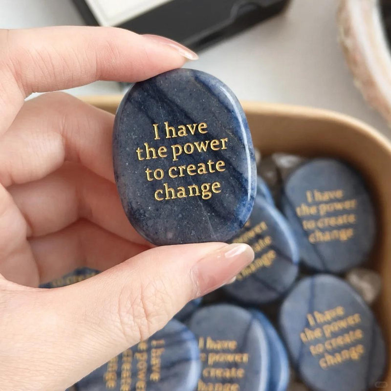 Hand holding blue sodalite affirmation stone engraved 'I have the power to create change' for spiritual growth and motivation