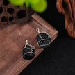 Wire-wrapped black crystal pendants for protection and spiritual growth, displayed on wood with lotus pod.