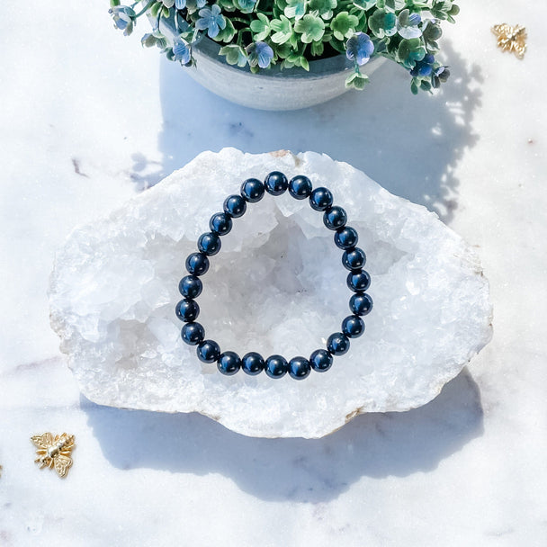 Deep blue gemstone bracelet on crystal geode, ideal for protection and spiritual growth