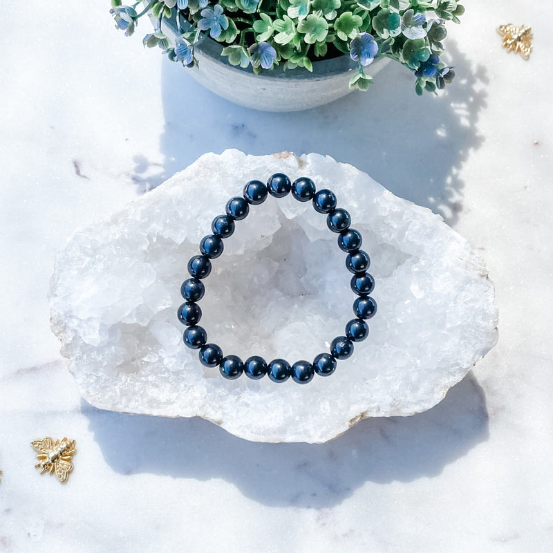 Deep blue gemstone bracelet on crystal geode, ideal for protection and spiritual growth