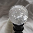 Clear quartz crystal sphere on black stand, healing crystal for spiritual growth and protection